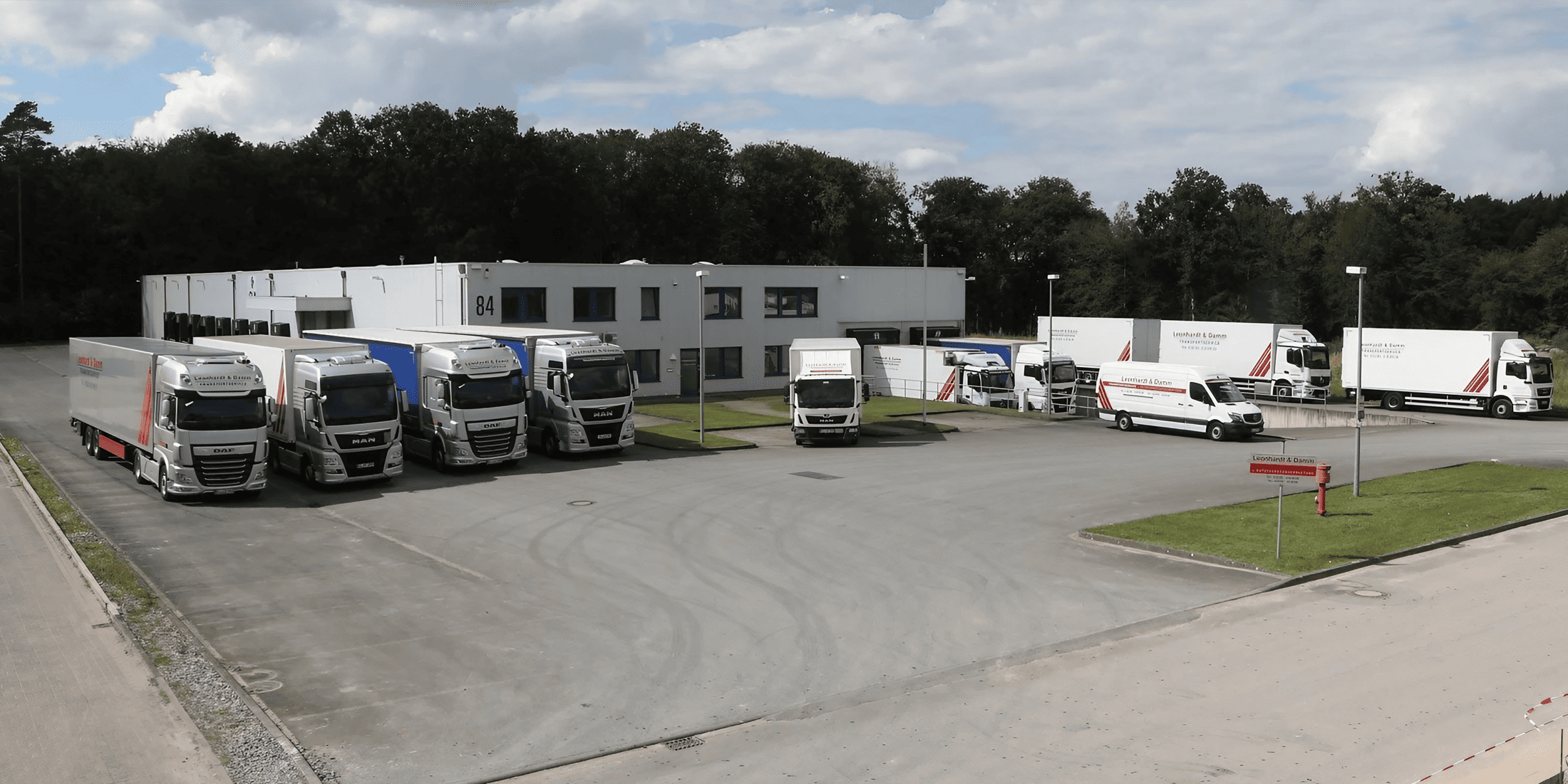 Mehrere Lastwagen stehen vor einem Gebäude geparkt